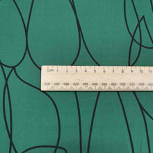 Load image into Gallery viewer, Klee is a stunning pure cotton with continuous, large scale, line drawings. Black on an emerald green background, available at Minerva's Bower. Image includes a ruler for scale