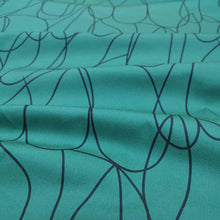 Load image into Gallery viewer, Klee is a stunning pure cotton with continuous, large scale, line drawings. Black on an emerald green background, available at Minerva's Bower. Fabric is draped across bench