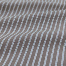 Load image into Gallery viewer, Flat lay of Joy cotton seersucker in fawn colourway. Available at Minerva's Bower. Fabric draped to show how it handles
