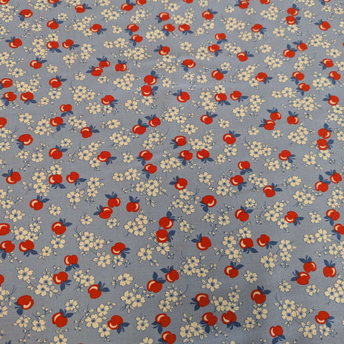 Flat lay of fabric with red apples and white flowers on a blue background in a vintage style, for sale at Minerva's Bower