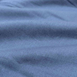 Flat lay of Anderson linen cotton in bluebell colourway. Available at Minerva's Bower. Fabric draped to show how it handles