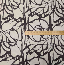 Load image into Gallery viewer, Fabric with black leaf pattern on a beige background, ruler for scale. Available at Minerva's Bower