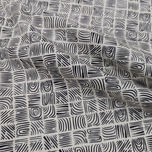 Black and cream woodblock patterned 100% cotton Art Gallery fabric, draped to show weight