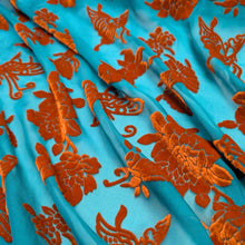 Load image into Gallery viewer, Orange silk devore velvet butterflies and flowers on a jade background. Available at Minerva's Bower. Fabric draped to show how it handles