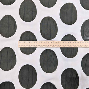 Flat lay of Crinkle Spot, a cream and Olive cotton Voile. Available at Minerva's Bower. A ruler is included for scale