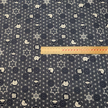 Load image into Gallery viewer, Pattern of cat faces and text on a dark  blue background of cotton dobby fabric. Made in Japan. Available at Minerva's Bower. Ruler included for scale