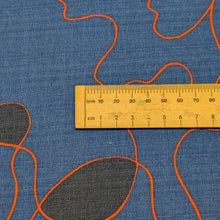 Load image into Gallery viewer, Abstract pattern with orange and black lines on a blue background of cotton dobby fabric. Available at Minerva's Bower. Ruler included for scale