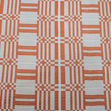 Load image into Gallery viewer, Flat lay of pure Indian cotton jacquard, Fableism Astrid Weave, in orange colourway. Available from Minerva&#39;s Bower