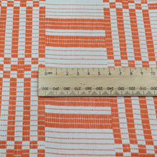 Load image into Gallery viewer, Flat lay of pure Indian cotton jacquard, Fableism Astrid Weave, in orange colourway. Available from Minerva&#39;s Bower. Ruler included for scale