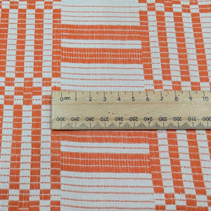 Flat lay of pure Indian cotton jacquard, Fableism Astrid Weave, in orange colourway. Available from Minerva's Bower. Ruler included for scale