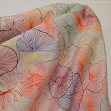 Load image into Gallery viewer, Neon embroidered tencel fabric in abstract floral shapes. Available at Minerva's Bower. Fabric draped to show how it handles