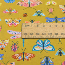 Load image into Gallery viewer, Close up flat lay of Thread and Ink 100% cotton, Flutter By, mustard cloth with all over butterfly dragonfly and insect print , ruler included for scale- available at Minerva's Bower
