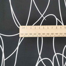 Load image into Gallery viewer, Klee is a stunning pure cotton with continuous, large scale, line drawings. White lines on a black background, available at Minerva&#39;s Bower. Image includes a ruler for scale