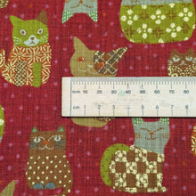 Load image into Gallery viewer, Pattern of colourful cats on a red cotton dobby background. Made in Japan. Available at Minerva's Bower. Ruler included for scale