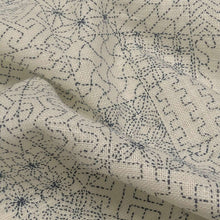 Load image into Gallery viewer, Patterned fabric with geometric sashiko design on a cream cotton background. Made in Japan. Available at Minerva's Bower. Fabric draped to show how it handles