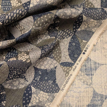 Load image into Gallery viewer, Patterned cotton fabric with circular shapes in shades of grey, brown, and blue. Made in Japan. Available at Minerva's Bower. Fabric draped to show how it handles