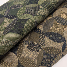 Load image into Gallery viewer, Patterned cotton fabric with circular shapes in shades of grey, brown, and blue. Made in Japan. Available at Minerva's Bower. Fabric draped to show how it handles