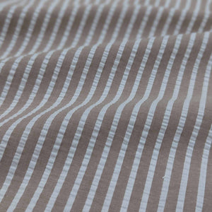 Flat lay of Joy cotton seersucker in fawn colourway. Available at Minerva's Bower. Fabric draped to show how it handles