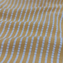 Load image into Gallery viewer, Flat lay of Joy cotton seersucker in mango colourway. Available at Minerva&#39;s Bower. Fabric draped to show how it handles