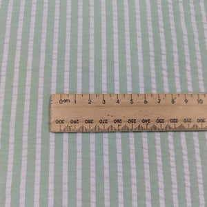 Flat lay of Joy cotton seersucker in mint colourway. Available at Minerva's Bower. Ruler included to show scale