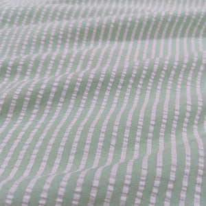 Flat lay of Joy cotton seersucker in mint colourway. Available at Minerva's Bower. Fabric draped to show scale