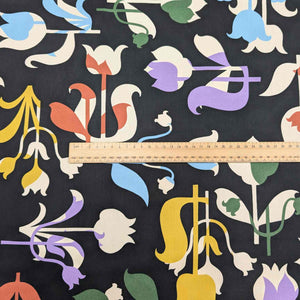 Colorful floral pattern on black Liberty of London fabric with a ruler for scale. Available at Minerva's Bower