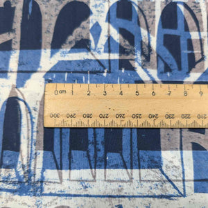 Liberty of London textured fabric with architectural pattern and a wooden ruler for scale. Available at Minerva's Bower 