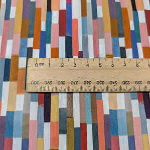 Colorful geometric patterned Liberty of London fabric with a wooden ruler for scale. Available at Minerva's Bower