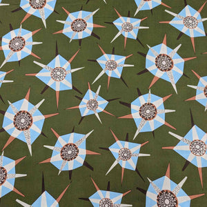 Liberty of London pattern of blue and white geometric shapes on a green background. Available at Minerva's Bower