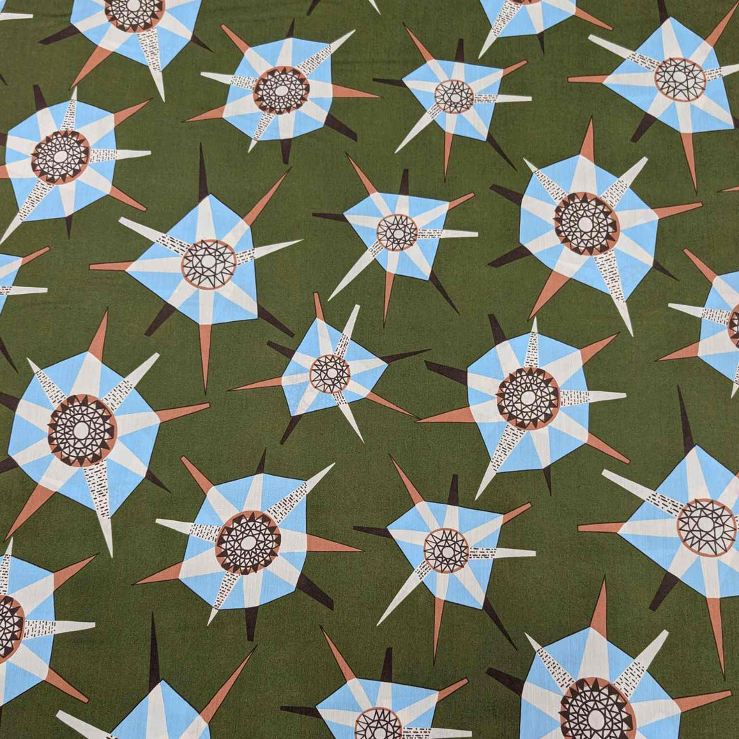 Liberty of London pattern of blue and white geometric shapes on a green background. Available at Minerva's Bower