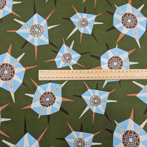 Liberty of London patterned fabric with star shapes and a ruler for scale on a green background. Available at Minerva's Bower