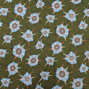 Liberty of London patterned fabric with blue and brown geometric shapes on a green background. Available at Minerva's Bower