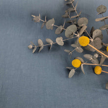 Load image into Gallery viewer, Flat lay of 200gsm 100% Linen Antique Wash, Denim, foliage included - for sale at Minerva's Bower