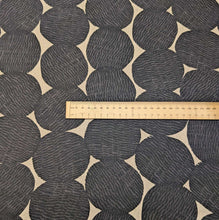 Load image into Gallery viewer, Pattern of black circles on a beige cotton/linen fabric background. Made in Japan. Available at Minerva's Bower. Ruler included for scale
