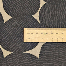Load image into Gallery viewer, Pattern of black circles on a beige cotton/linen fabric background. Made in Japan. Available at Minerva's Bower. Ruler included for scale