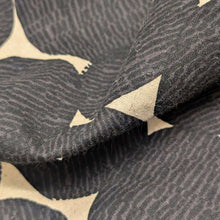 Load image into Gallery viewer, Pattern of black circles on a beige cotton/linen fabric background. Made in Japan. Available at Minerva's Bower. Fabric draped to show how it handles