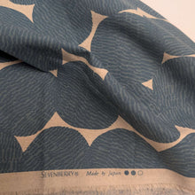 Load image into Gallery viewer, Pattern of dark grey circles on a beige cotton/linen fabric background. Made in Japan. Available at Minerva's Bower. Fabric draped to show how it handles