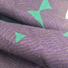 Load image into Gallery viewer, Pattern of purple circles on a teal cotton /linen fabric background. Made in Japan. Available at Minerva's Bower. Fabric draped to show how it handles