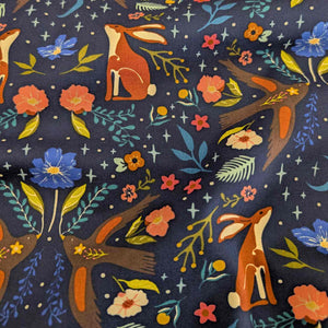 Draped Art Gallery cotton fabric with foxes, flowers, and leaves on a dark blue background