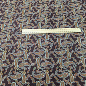 Paisley patterned burgundy lyocell fabric with a ruler for scale, for sale at Minerva's Bower