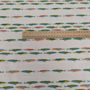 Art gallery fabric with a Pattern of colourful whales on a cream base, for sale at Minerva's Bower, ruler included for scale