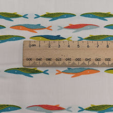 Load image into Gallery viewer, Close up of Art gallery fabric with a Pattern of colourful whales on a cream base, for sale at Minerva&#39;s Bower , ruler included for scale