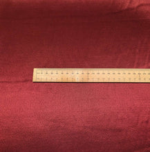 Load image into Gallery viewer, A close-up of a red viscose twill satin fabric surface, our Prom Viscose in Claret. Available at Minerva's Bower. Ruler included for scale