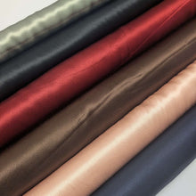 Load image into Gallery viewer, A close-up of a satin twill fabrics, our Prom Viscose,different colours. Available at Minerva's Bower. 