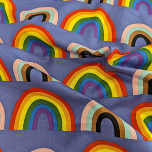 Drape of Alexander Henry cotton Fabric with rainbow pattern on a blue background, for sale at Minerva's Bower