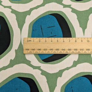 Close up of Rayon with circular teal and black shapes and green and cream accents, for sale at Minerva's Bower, ruler included for scale