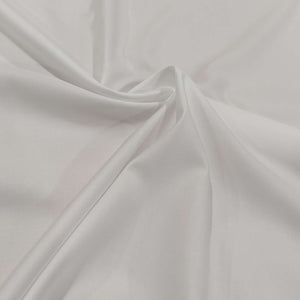 Close-up of white 100% cotton with light sheen. fabric is folded to show drape. Available at Minerva's Bower