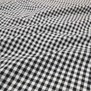 Flat lay of Spencer cotton linen check in black. Available at Minerva's Bower. Fabric draped to show how it handles