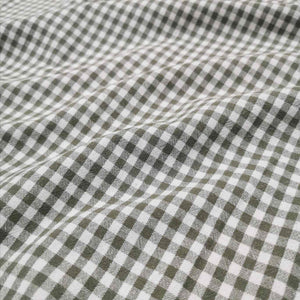 Flat lay of Spencer cotton linen check in olive. Available at Minerva's Bower. Fabric draped to show ow it handles