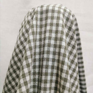 Flat lay of Spencer cotton linen check in olive. Available at Minerva's Bower. Fabric draped to show ow it handles